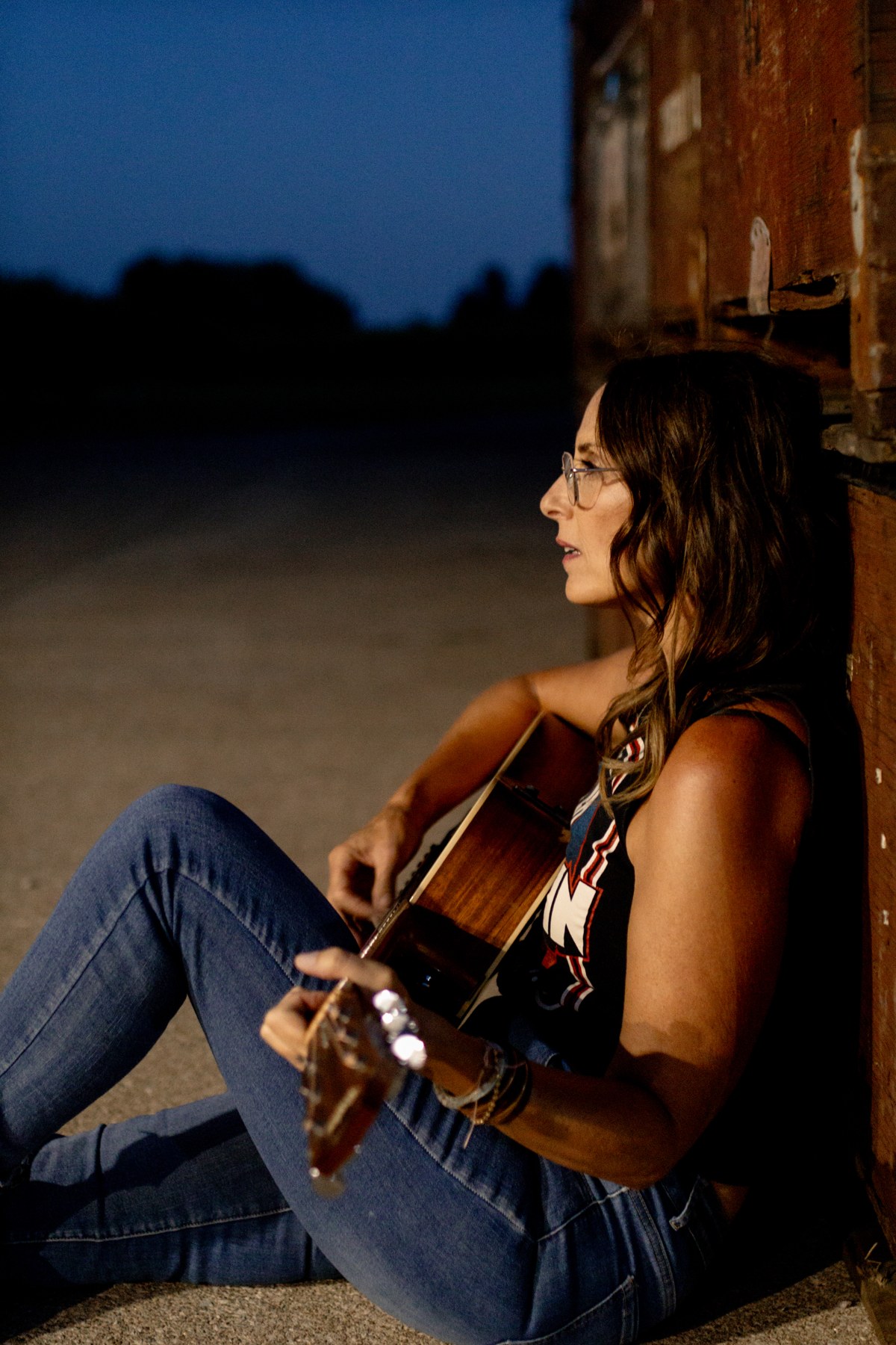 Michelle Hedley with her guitar at night in a Led Zeppelin shirt